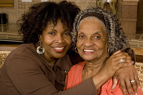 African american mother and daughter hugging and smiling