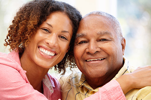 Young woman hugging her father, both smiling